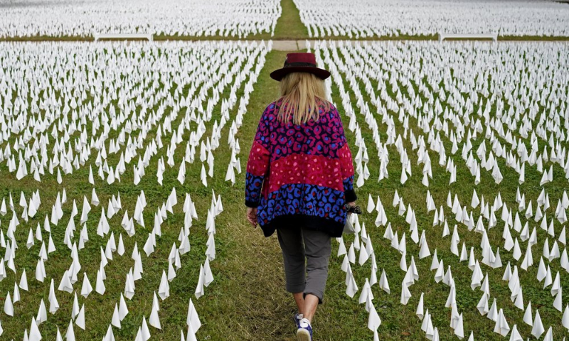 In this Oct 27 file photo, artist Suzanne Brennan Firstenberg walks among thousands of white flags planted in remembrance of Americans who have died of Covid-19 near Robert F. Kennedy Memorial Stadium in Washington. — AP In this Oct 27 file photo, artist Suzanne Brennan Firstenberg walks among thousands of white flags planted in remembrance of Americans who have died of Covid-19 near Robert F. Kennedy Memorial Stadium in Washington. — AP