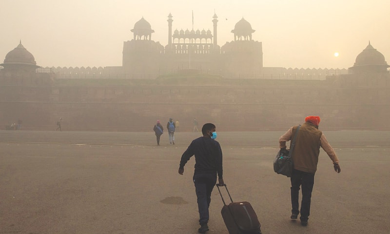 NEW DELHI: A few people pictured in front of the Red Fort on a smoggy morning. — Reuters