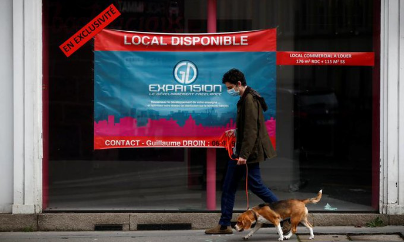 A man walks his dog past a commercial space for rent in a street in Nantes, France on Tuesday. — Reuters