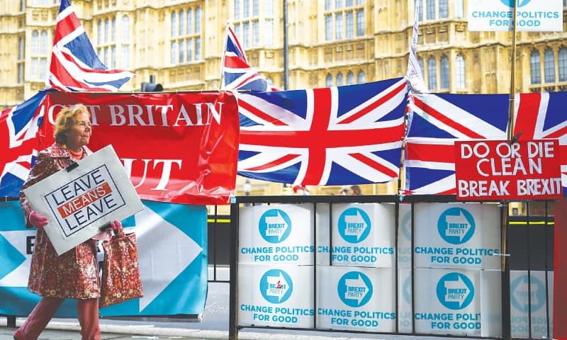 In this file photo, a pro-Brexit protester walks with a placard outside the Houses of Parliament.—Reuters/File