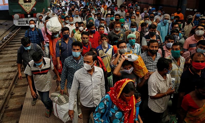 Passengers wearing protective face masks walk on a platform upon disembarking from a suburban train in Kolkata on November 11. &mdash; Reuters