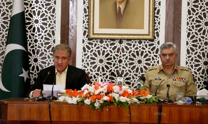 Foreign Minister Shah Mahmood Qureshi, left, briefs the media while military spokesman Maj Gen Babar Iftikhar watches during a joint press conference in Islamabad on Saturday. — AP