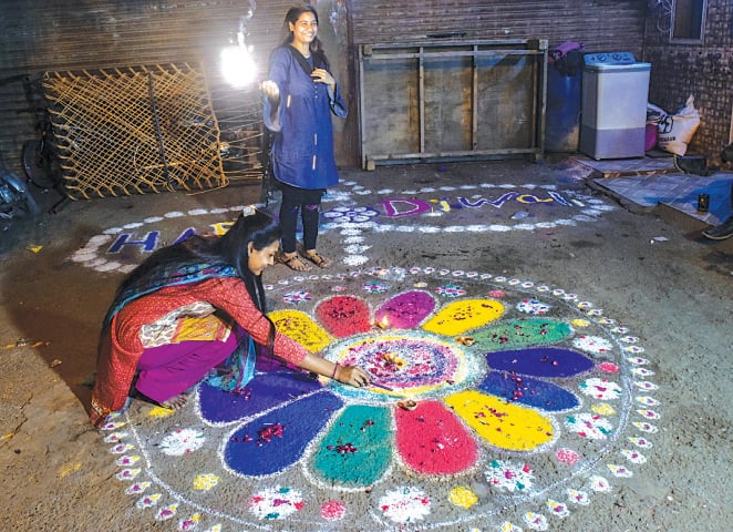 A GIRL arranges earthen lamps and another one enjoys fireworks at Swami Narayan Mandir in Karachi as Hindus celebrate the Diwali festival on Saturday.&mdash;White Star