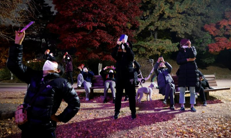 People take pictures as drones fly in formation showing messages of hope, amid the coronavirus disease outbreak, in Seoul, South Korea on Nov 13. &mdash; Reuters