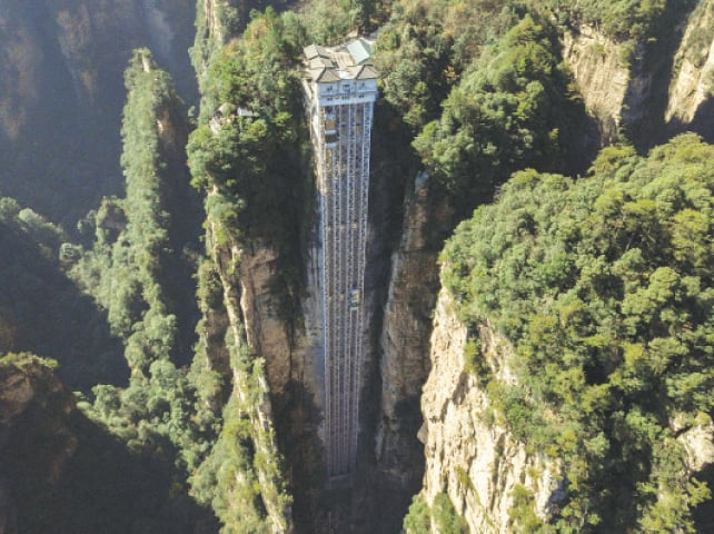 ZHANGJIAJIE (China): An aerial view of elevators that dare tourists to take a literally cliff-hanger of a ride to the top of a towering peak in China’s Hunan province. The world’s highest outdoor lift rewards brave tourists with breathtaking views of a majestic cliff that inspired the landscape for the blockbuster movie, Avatar.—AFP