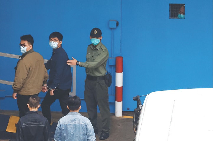 Hong Kong: Pro-democracy activists Ivan Lam and Joshua Wong arrive at a reception centre by prison van after pleading guilty to charges of organising and inciting an unauthorised assembly near the police headquarters during last year’s anti-government protests.—Reuters