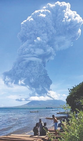 Lembata (Indonesia): Residents watch as Mount Ili Lewotolok spews ash during a volcanic eruption
on Sunday.—AFP