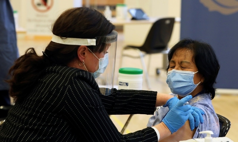 A healthcare worker administers a Pfizer/BioNTEch coronavirus vaccine to a patient at The Michener Institute in Toronto. — Reuters