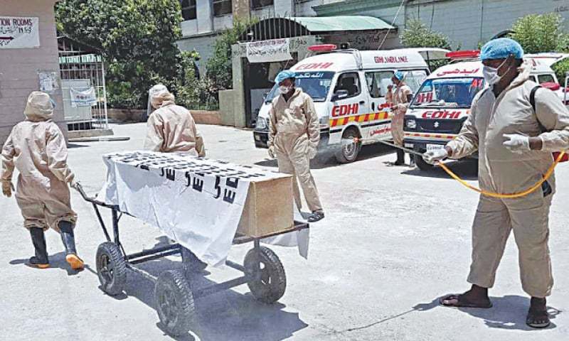 THE coffin of a man declared Covid-19 patient is being taken out of the Liaquat University Hospital in this file photo. — APP