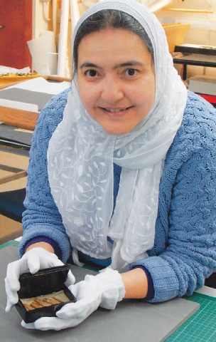 Curatorial assistant Abeer Eladany poses with pieces of cedar wood discovered in 1872 inside Egypt’s Great Pyramid and recently rediscovered in the collection of the University of Aberdeen’s museum after being lost for more than 70 years.—AFP