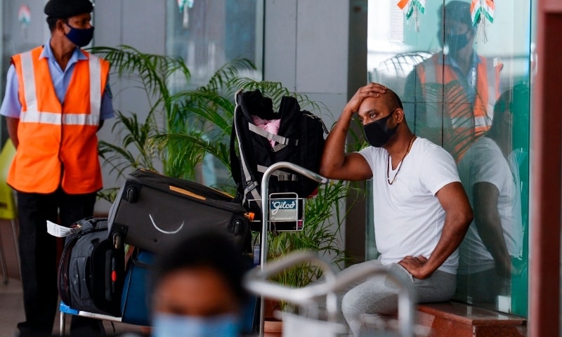 A man waits to be transported to a quarantine centre at Anna International Airport upon his arrival from the United Kingdom in Chennai on December 22. &mdash; AFP