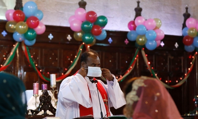 Pastor Shamoon, wears a protective mask as he leads the Christmas service at St Andrew's Church on Dec 25. &mdash; Reuters