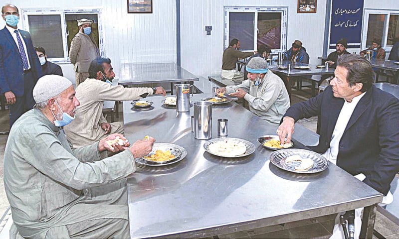 ISLAMABAD: Prime Minister Imran Khan having a meal with residents of Panahgah in Tarnol on Friday.&mdash;APP