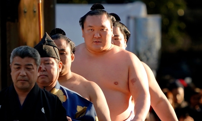 In this 2018 file photo, Sumo grand champion Hakuho, second from right, of Mongolia arrives to perform his ring entry form at the Meiji Shrine in Tokyo. &mdash; AP