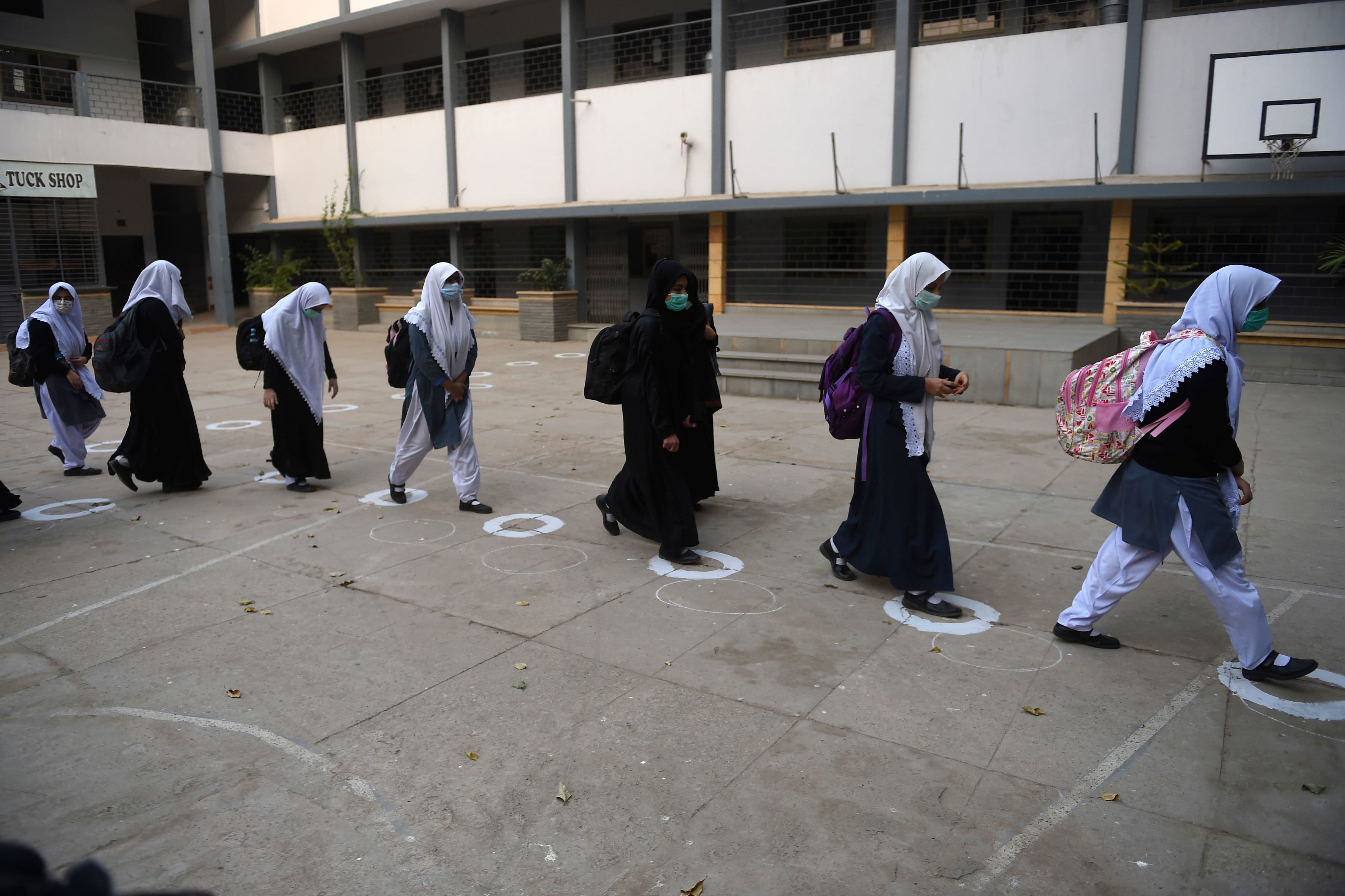 Students wearing facemasks arrive at the school in Karachi on January 18. — AFP