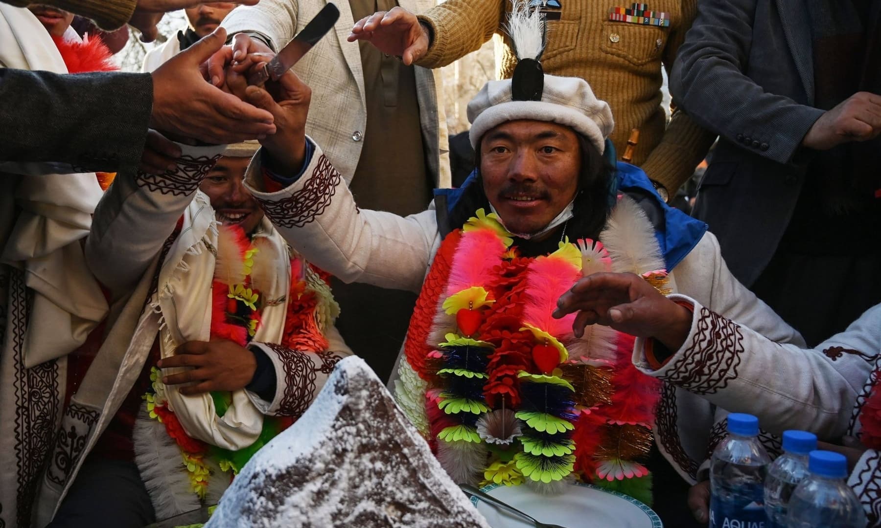 Nepal's climbers Nirmal Purja (L) and Mingma Sherpa (R) cut a cake upon their arrival after becoming the first to summit Pakistan's K2 in winter, during a ceremony at Shigar district in Gilgit-Baltistan, Jan 20, 2021. — AFP