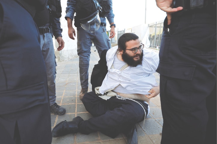 ASHDOD: Police detain an ultra-Orthodox Jew during the protest.—Reuters