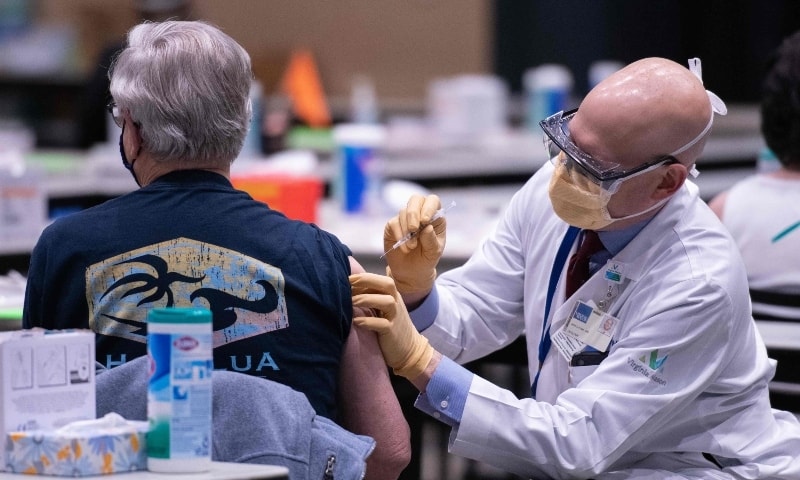 Chief clinical officer John Corman MD at Virginia Mason administers a dose of the Pfizer Covid-19 vaccine at the Amazon Meeting Center in downtown Seattle, Washington on January 24. &mdash; AFP