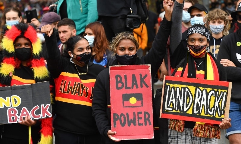 People raise their fists as thousands of people attend an Australia Day protest in Melbourne in January 26. — AFP