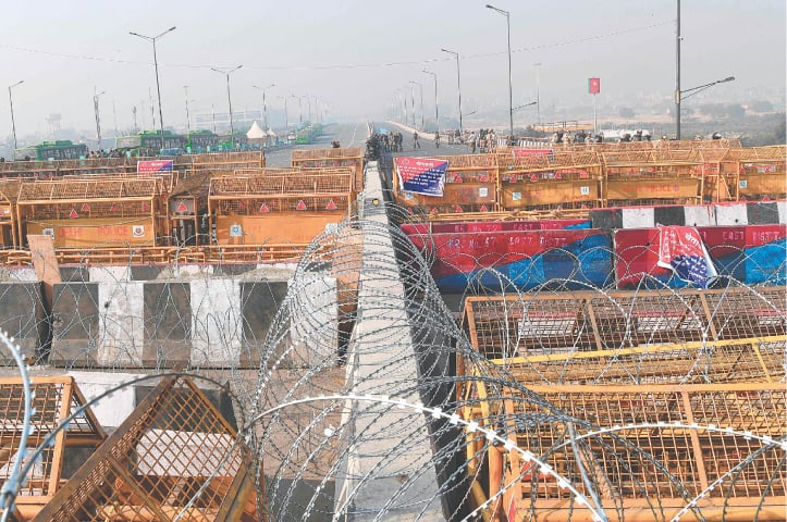 GHAZIABAD: Security personnel stand guard next to police barricades along a blocked highway as farmers continue their protest against the Indian government’s agricultural reforms.—AFP