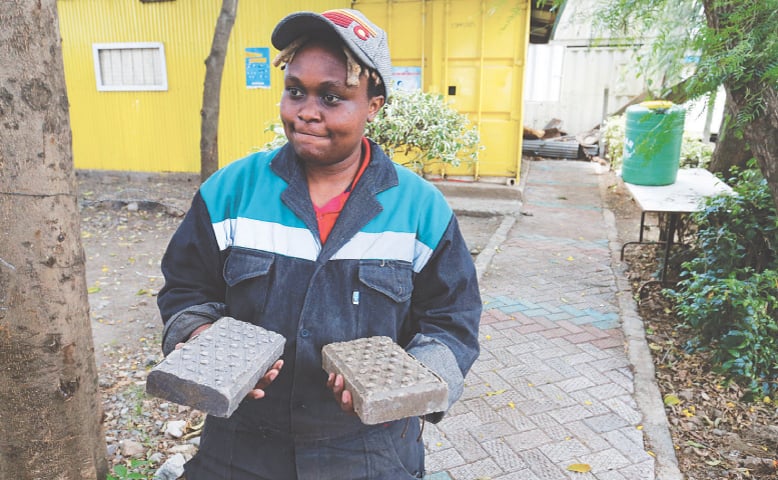 Nzambi Matee, the founder of Kenya’s Gjenge Makers, a social enterprise that recycles and up-cycles waste plastic into construction products such as paving bricks, shows pavers to the media at an event on Tuesday.—Reuters