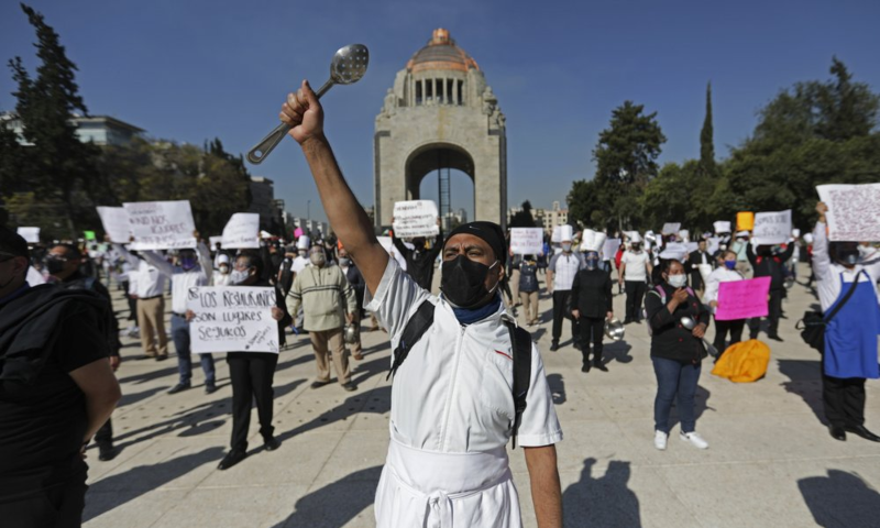 A worker with a metal cooking implement joins fellow restaurant employees in a protest against the Covid-19 "red alert&rdquo; shutdown that suspended restaurants&rsquo; limited seating and returned them to takeout and delivery only, in Mexico City, February 4. &mdash; AP