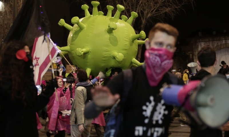 Israeli protesters march with a large inflatable model of the coronavirus on their way to Israeli Prime Minister Benjamin Netanyahu's official residence in Jerusalem, February 6. — AP