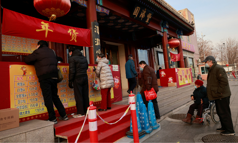People line up at the street stall of Fengzeyuan restaurant to buy dishes typical for Lunar New Year celebrations, following an outbreak of Covid-19 in Beijing, China on February 8, 2021. — Reuters