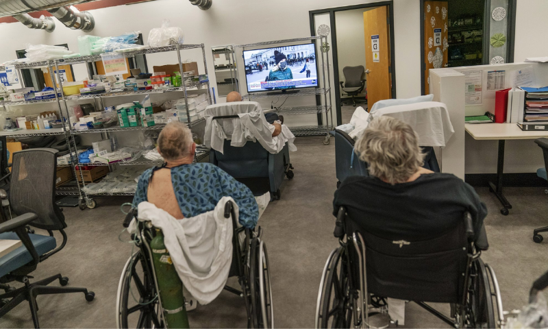 Covid-19 patients watch television in a common area of the field hospital. — AP
