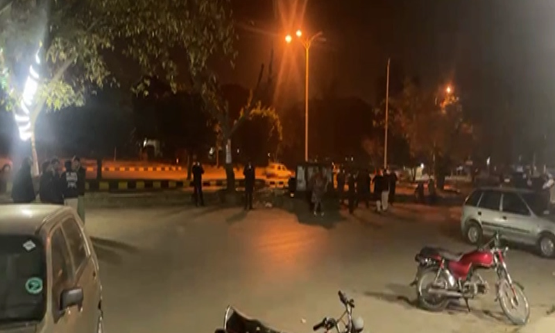 People gather outside buildings after earthquake tremors were felt in Islamabad on Friday. — DawnNewsTV