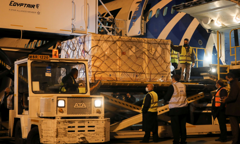Workers offload pallets containing coronavirus vaccine 'Sinopharm' doses as they arrive from China at Cairo International Airport amid the coronavirus pandemic in Cairo, Egypt on Tuesday. &mdash; AP