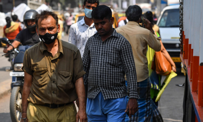 A pedestrian walks along a road without wearing a face mask despite restrictions imposed as a preventive measure against the spread of the Covid-19 coronavirus, in Mumbai. — AFP