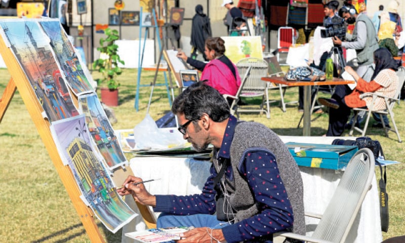 A local band entertains visitors, artists paints on a canvas at a stall, a woman looks at dresses on display and an artisan carves on a stone slab at the art and craft bazaar at the PNCA on Sunday. — Photos by Mohammad Asim