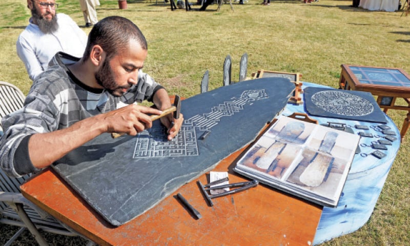 A local band entertains visitors, artists paints on a canvas at a stall, a woman looks at dresses on display and an artisan carves on a stone slab at the art and craft bazaar at the PNCA on Sunday. — Photos by Mohammad Asim