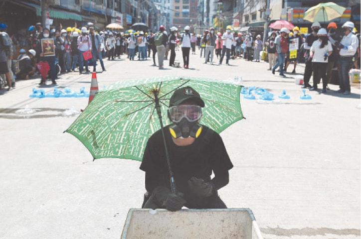 A demonstrator holds an umbrella during a protest against the military coup on Monday.—Reuters