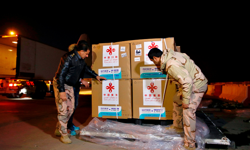 Air freight workers unload the first batch of doses of the Sinopharm vaccine against the coronavirus after it arrived at Baghdad International Airport. &mdash; AP