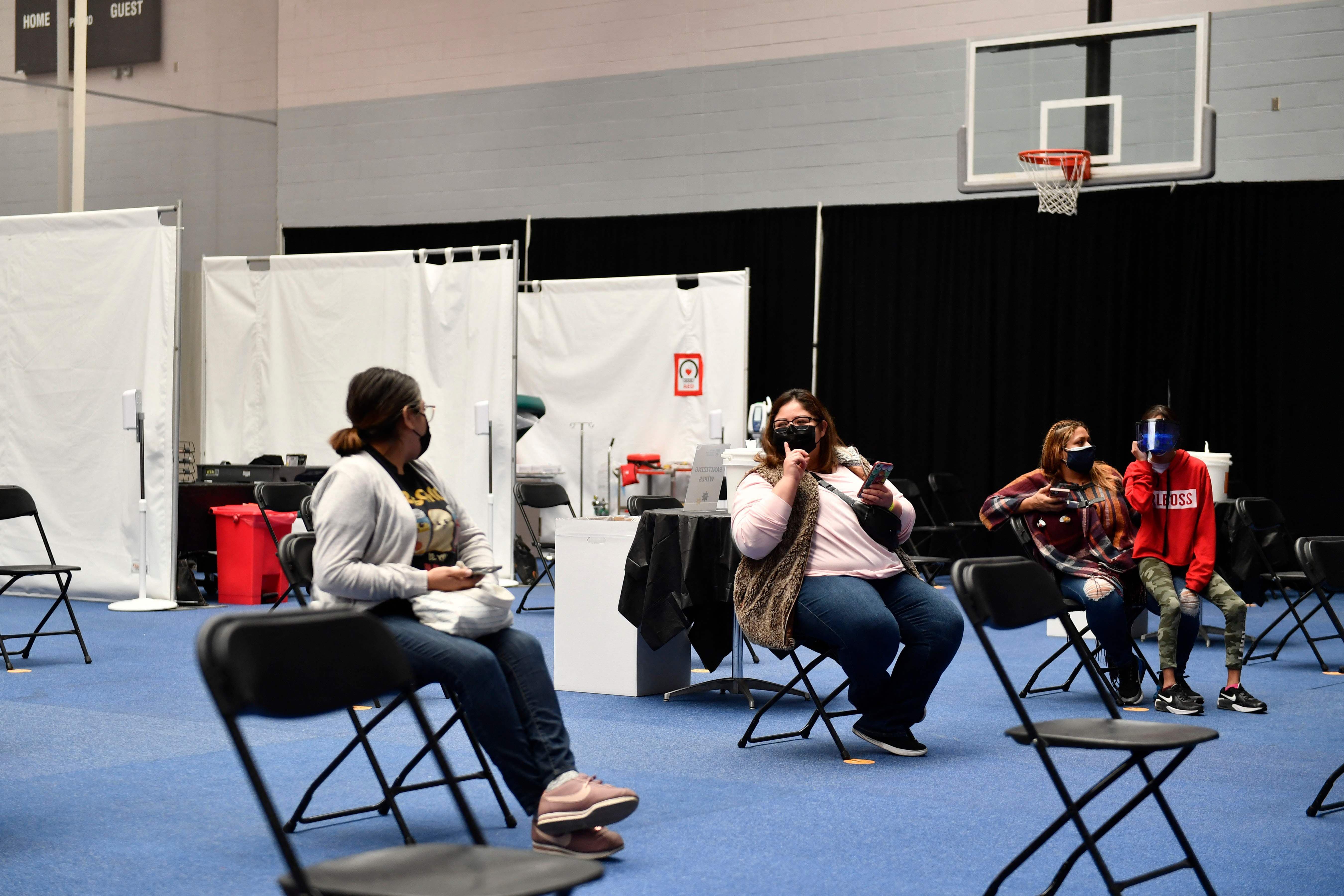 People wait in an observation area after receiving a dose of the Moderna Covid-19 vaccine at a clinic for Catholic school education workers at a vaccination site at Loyola Marymount University on March 8 in Los Angeles. — AFP