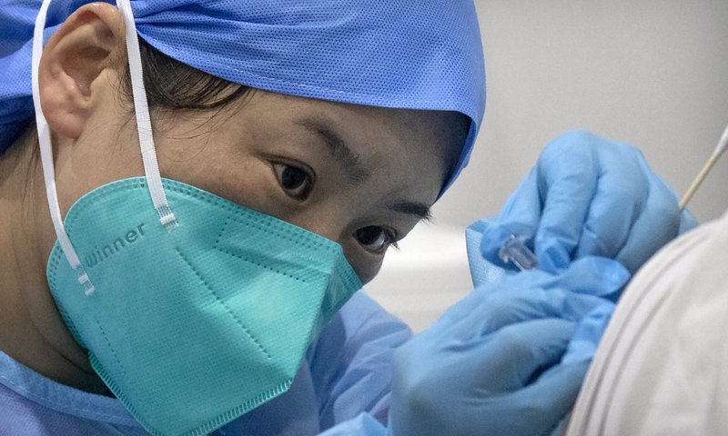 A medical worker gives a coronavirus vaccine shot to a patient at a vaccination facility in Beijing, China. — AP