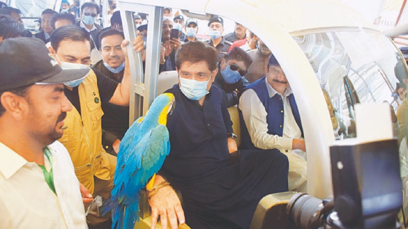 Murad Ali Shah inspects a parrot at the event.—Umair Ali