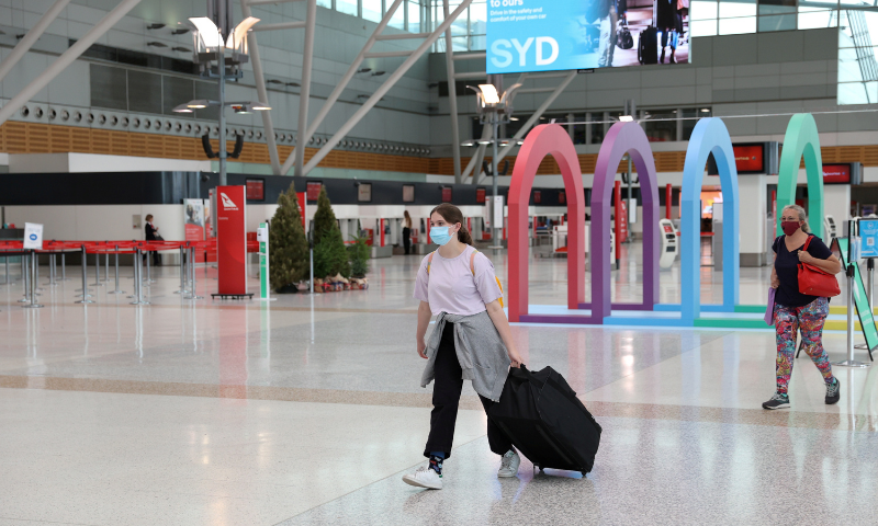 People wearing masks walk through a mostly empty domestic terminal at Sydney Airport in Sydney, Australia. — Reuters/File