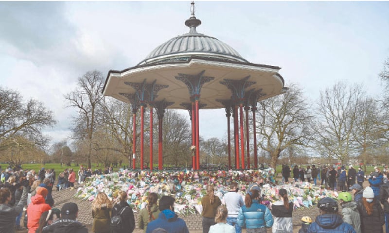 LONDON: Well-wishers gather near bouquets laid in memory of Sarah Everard at the bandstand in south London on Sunday, a day after police officers scuffled with people holding a vigil for the murdered woman there.&mdash;AFP