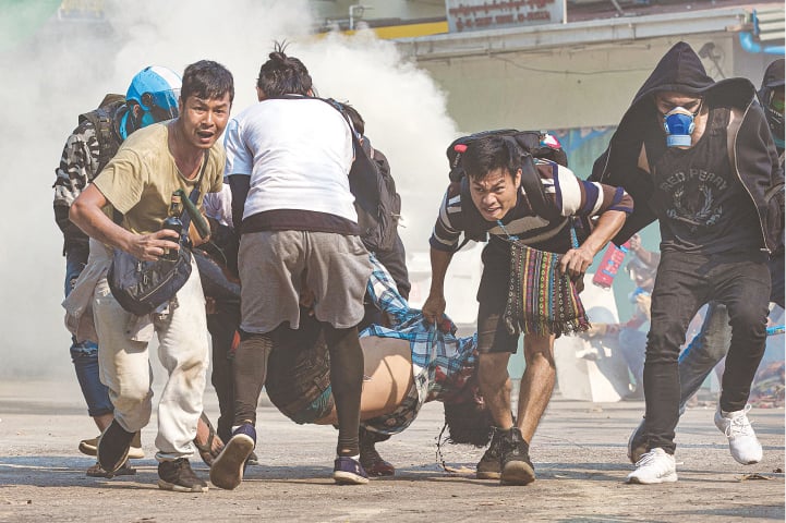 YANGON: Protesters carry a wounded man during a crackdown on demonstrations against the military coup in Myanmar on Wednesday. Protesters fired slingshots and threw Molotov cocktails towards security forces after apparently coming under fire. The growing resistance comes after one organisation said that more than 200 people have been killed since the Feb 1 takeover.&mdash;AFP