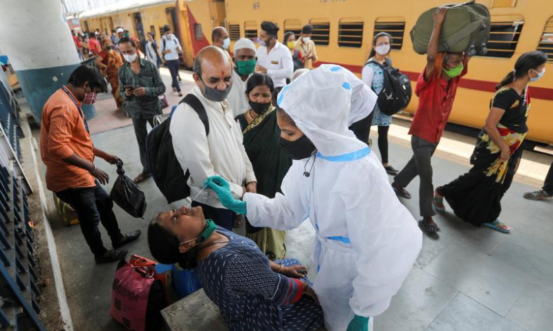 A health worker in personal protective equipment (PPE) collects a swab sample from a woman during a rapid antigen testing campaign for the coronavirus at a railway station platform in Mumbai, India. — Reuters