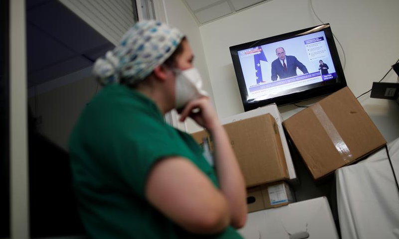 Medical staff members watch French Prime Minister Jean Castex on TV as he addresses the nation about the Covid-19 outbreak and the lockdown restrictions, Stains, France, March 18. — Reuters