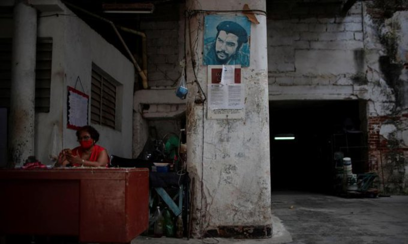 A person works in a parking lot beside an image of late revolutionary hero Ernesto "Che" Guevara amid concerns about the spread of the coronavirus disease in Havana on March 17. — Reuters