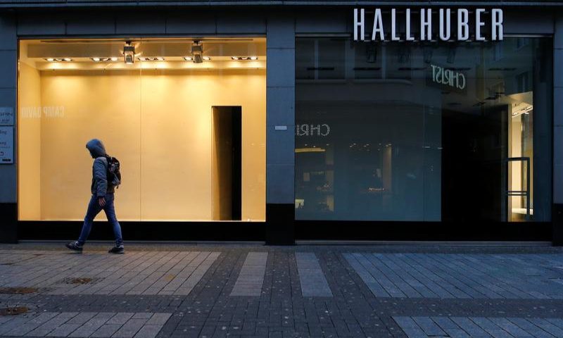 A man walks along a closed shop at the main shopping street Hohe Strasse amid the coronavirus pandemic in Cologne, Germany. &mdash; Reuters