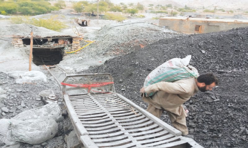 Dilbar Khan Swati carrying a coal-filled sack at the depot in Mach.—Photo by writer