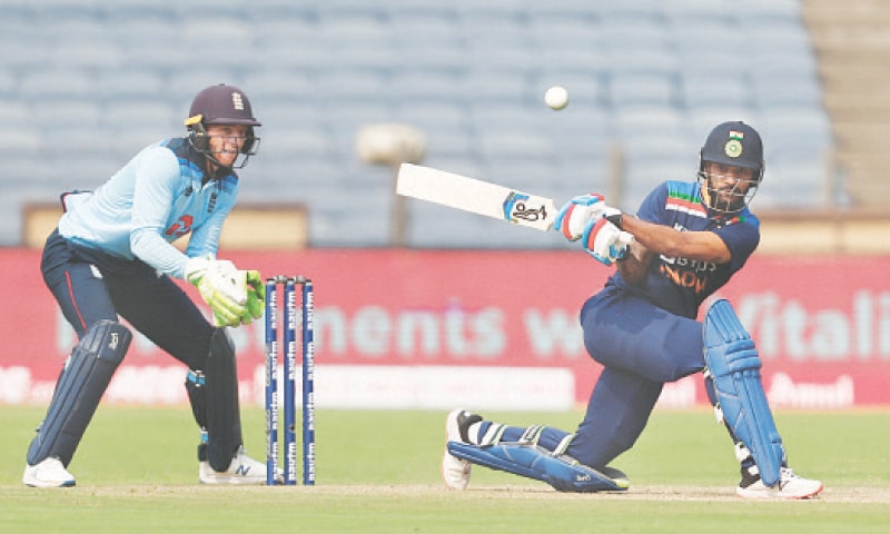 PUNE: Indian opener Shikhar Dhawan sweeps as England wicket-keeper Jos Buttler looks on during the first ODI at the Maharashtra Cricket Association Stadium on Tuesday.&mdash;Reuters