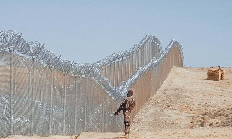 In this file photo, an army soldier stands guard along the newly fenced part of the Pak-Afghan border after Chief of the Army Staff 
Gen Qamar Javed Bajwa inaugurated the fencing work near the Panjpai area of Balochistan.—AFP/File