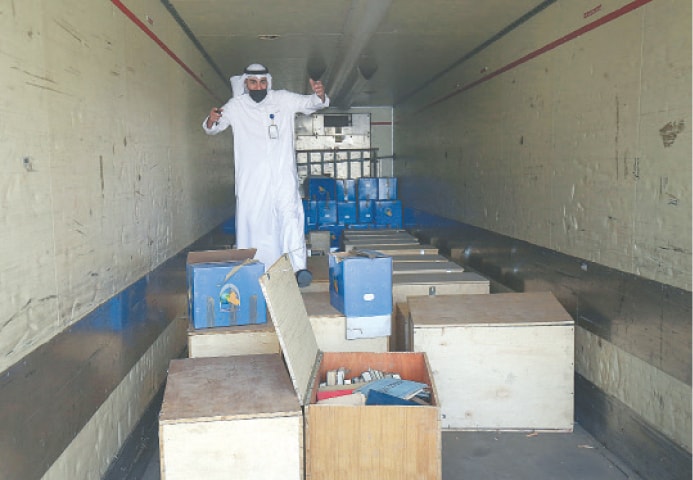 AN employee at the Kuwaiti information ministry inspects boxes in the back of a truck containing Kuwaiti archives seized during the Iraqi invasion in 1990.—AFP